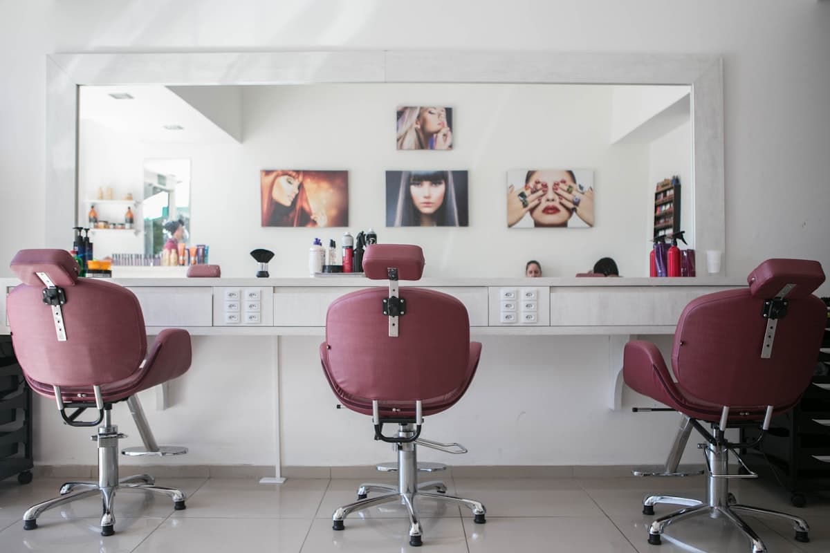 Rose-colored salon chairs at the styling bar